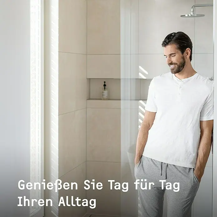Stiebel Eltron Durchlauferhitzer DHB 21 ST - 21 kW, Elektronisch, Geschlossen - Ein Mann in bequemer Kleidung lehnt an der Duschwand, genießt den Komfort und die entspannte Atmosphäre im Badezimmer.