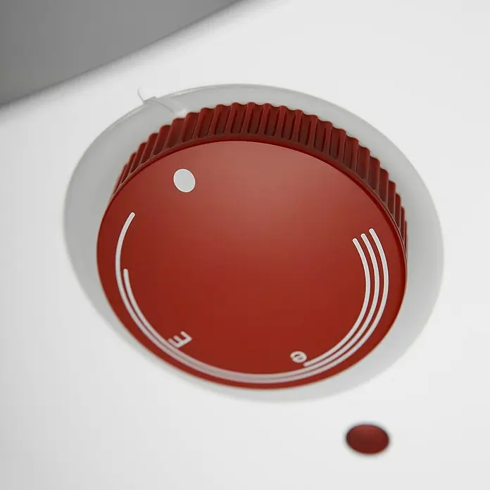 AEG Warmwasserspeicher Huz 5 Drop Stop - 5 l, Temperaturbereich: 35 °C - 85 °C, Untertischmontage - Nahaufnahme eines roten Drehknopfes mit weißen Markierungen, der auf einer weißen Oberfläche montiert ist.