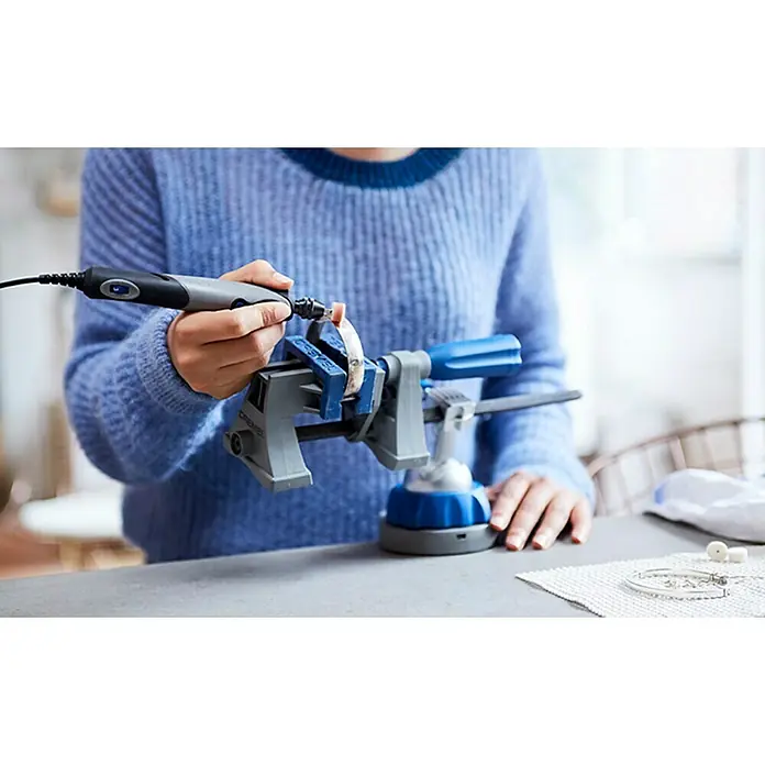 Dremel Elektro-Multifunktionswerkzeug 2050 Stylo+ - 9 W - Detailaufnahme einer Person, die mit einem Dremel Werkzeug an einer Schmuckarbeit arbeitet, die in einem Schraubstock fixiert ist.