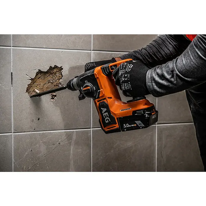 AEG Pro 18V Akku-Kombihammer BBH18BL2-018 V, Ohne Akku, 2,5 J - Nahaufnahme eines AEG Akku-Bohrhammers beim Bohren in eine geflieste Wand, ideal für Renovierungs- und Bauarbeiten.