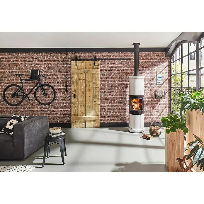 Papel pintado Ladrillo arena rojo - Ladrillo arena rojo - Salón con estufa de leña, puerta corredera de madera y bicicleta en la pared. La estufa proporciona calidez y ambiente.