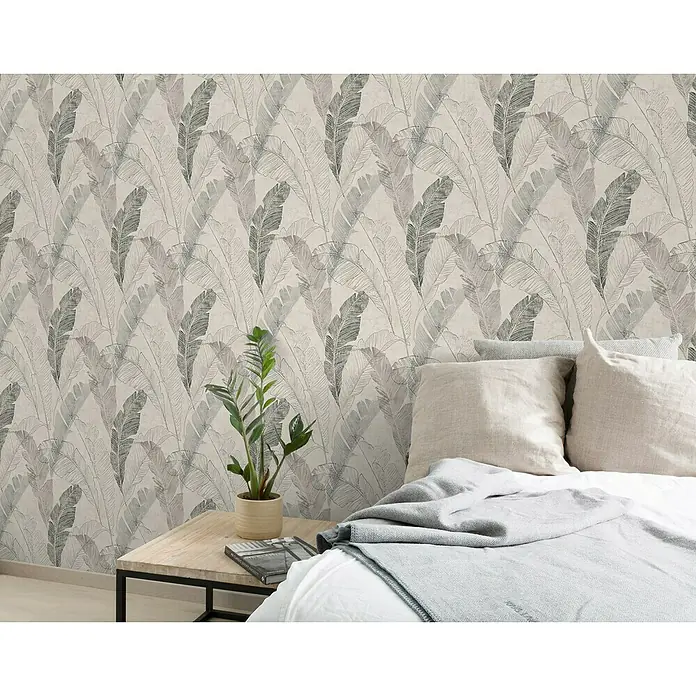 Papel pintado Vegetal hoja - Gris, 10 x 0,53 m - Primer plano de una Zamioculcas zamiifolia sobre una mesita de noche contra una pared con papel pintado de hojas de plumas, creando un ambiente de dormitorio sereno y elegante.