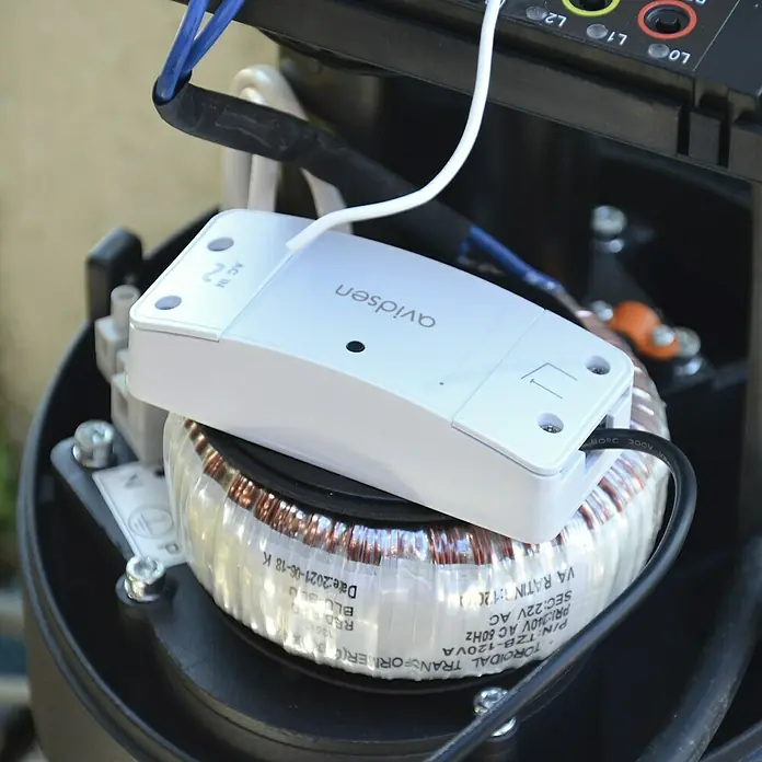Avidsen Módulo de comando inalámbrico WiFi - 50 m - Primer plano de un producto Avidsen montado sobre un transformador toroidal, con conexiones eléctricas visibles.