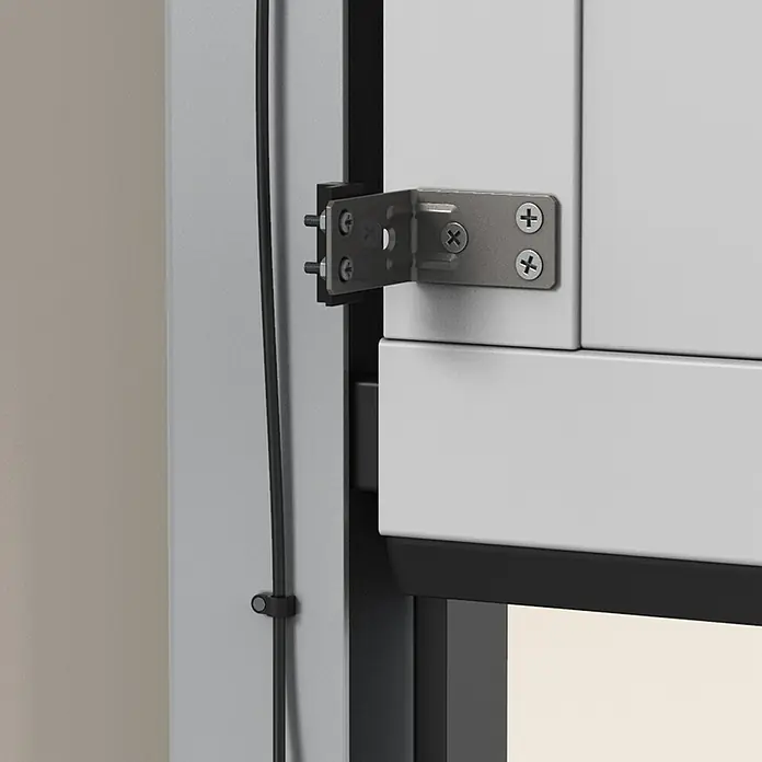 Avidsen Módulo de comando inalámbrico WiFi - 50 m - Primer plano de una bisagra de ventana plateada fijada a un marco de ventana blanco. Las bisagras están bien sujetas con tornillos.