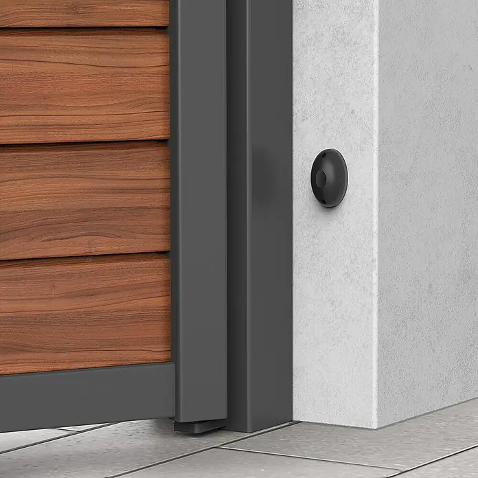 Avidsen Mecanismo de puerta de garaje Orane 510 con brazo articulado - Anchura puerta: 0 m - 2,5 m - Vista detallada de una puerta de madera moderna con marco gris y un sensor redondo negro en una pared blanca.