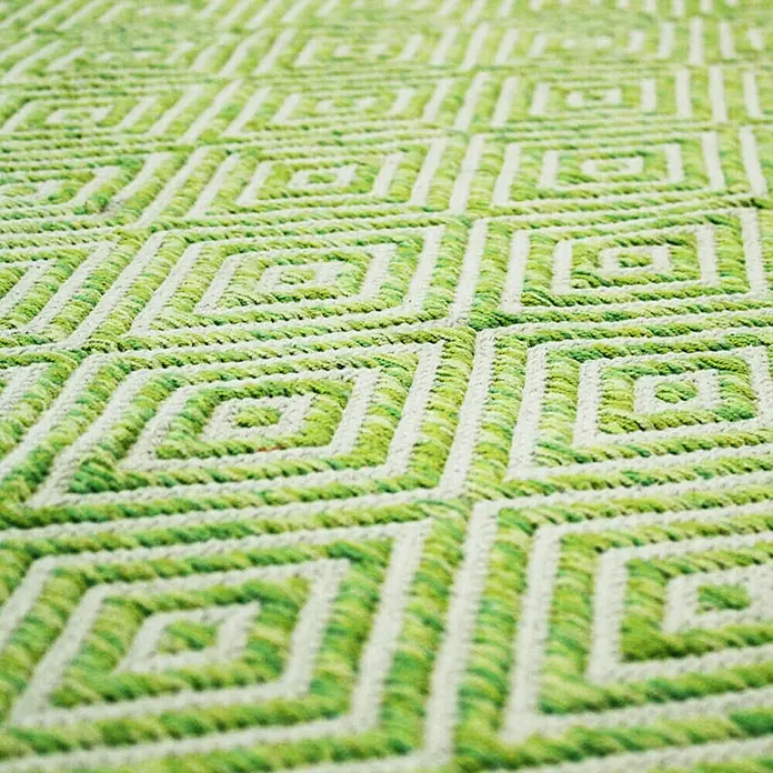 Kayoom Flachgewebeteppich Cocktail 300 - Grün, 150 x 80 cm, 100% Baumwolle - Nahaufnahme eines grünen Teppichs mit geometrischem Rautenmuster.