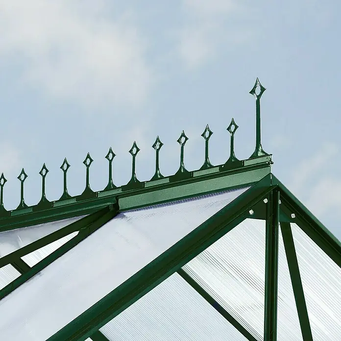 Vitavia Gewächshaus-Firstkrone - Smaragd, Passend für: Vitavia Gewächshaus Merkur 9900/Mars 9900/Uranus 9900/Cassandra 9900/Diana 9900 - Detailaufnahme eines Gewächshausdachs mit dekorativen Zierelementen und durchscheinenden Paneelen vor einem hellblauen Himmel.