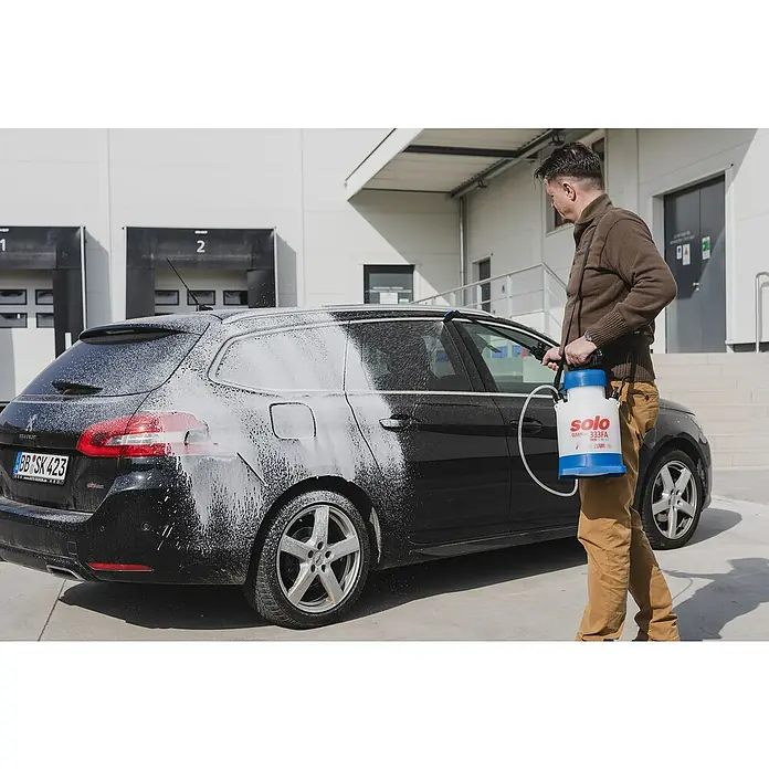 Solo Schaumsprüher Cleanline 333 FA - Füllmenge: 4 l - Ein Mann wäscht ein Auto mit einem SOLO 333FA Sprühgerät, das weiße Schaumseife auf die schwarze Oberfläche aufträgt.