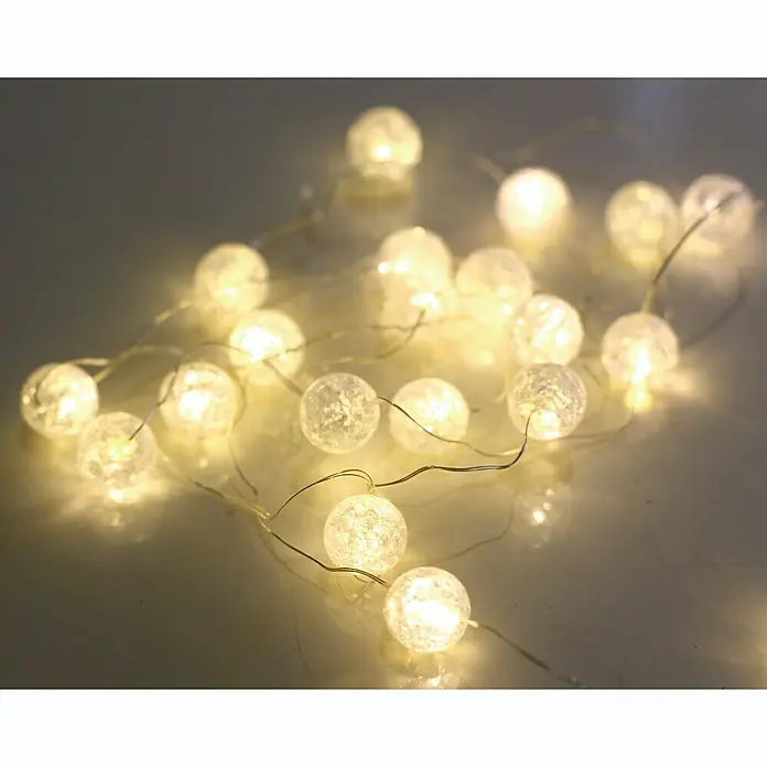 Globo LED-Lichterkette Venuto - Innen, Kabellänge: 1,9 m, Weiß, Rund - Nahaufnahme einer Lichterkette mit kugelförmigen Lampen, die ein warmes, funkelndes Licht ausstrahlen und eine festliche Atmosphäre schaffen.