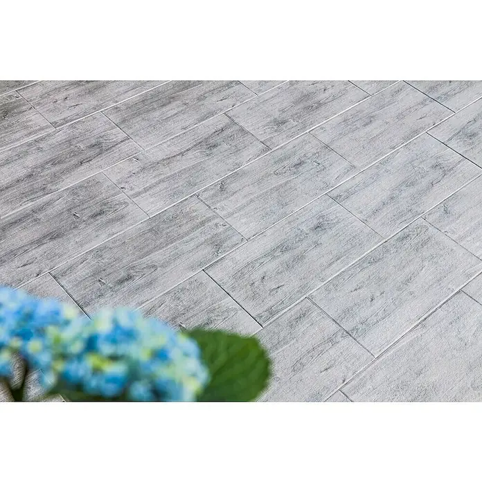 Diephaus Terrassenplatte Nashville - 60 x 30 x 4 cm, Mittelgrau, Beton - Nahaufnahme von hellgrauen Holzfliesen, die ein modernes und stilvolles Interieur zeigen. Die Fliesen imitieren Holzmaserung und Textur perfekt.