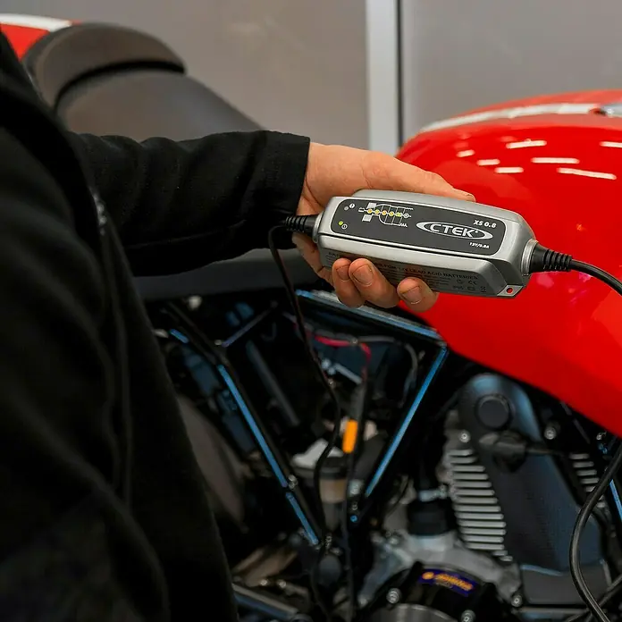 CTEK Automatik-Ladegerät XS 0.8 - 100 Ah - Ein CTEK XS 0.8 Batterieladegerät wird in der Hand gehalten, um eine Motorradbatterie zu laden.