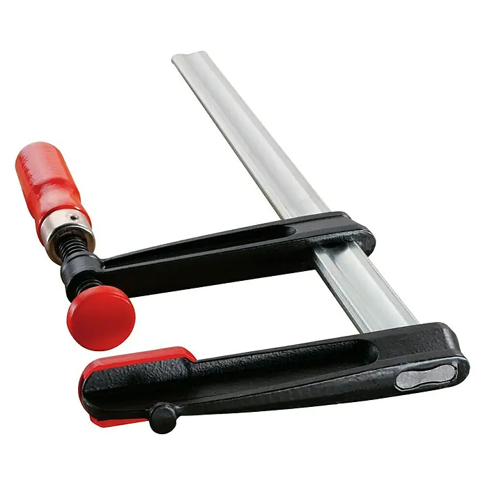 Bessey Schraubzwinge TPN30S12BE - Spannweite: 300 mm, Spannkraft: 6.000 N, Ausladung: 120 mm - Eine Detailaufnahme einer soliden Schraubzwinge mit rotem Holzgriff und schwarzem Rahmen, die auf einer ebenen Fläche steht.