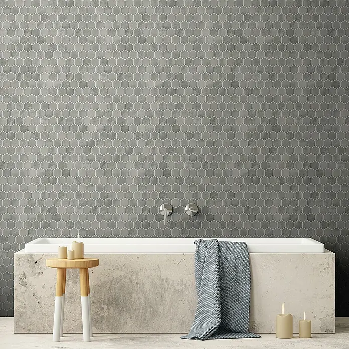 Mosaikfliese Hexagon HX CURIO ZLG - 32,5 x 28,1 cm, Grau, Matt - Badewanne mit grauen Mosaikfliesen an der Wand und einer Dekoration mit Kerzen und Handtuch, die eine entspannende Atmosphäre schaffen.