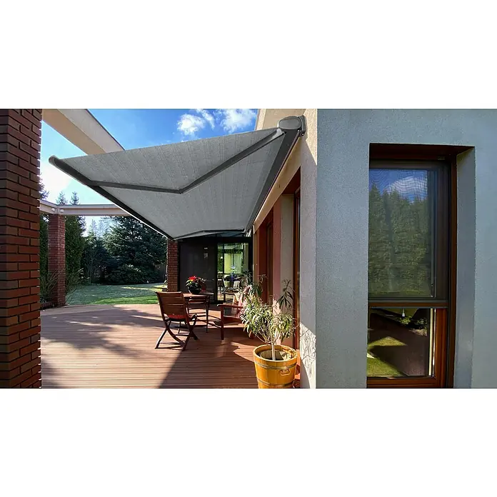 SM Vollkassettenmarkise REC-196Hellgrau, Farbe Gestell: Weißaluminum, Breite: 3,6 m, Ausfall: 2,5 m - Eine graue Gelenkarmmarkise spendet Schatten auf einer Holzterrasse mit Gartenmöbeln und Topfpflanzen vor einem modernen Haus.