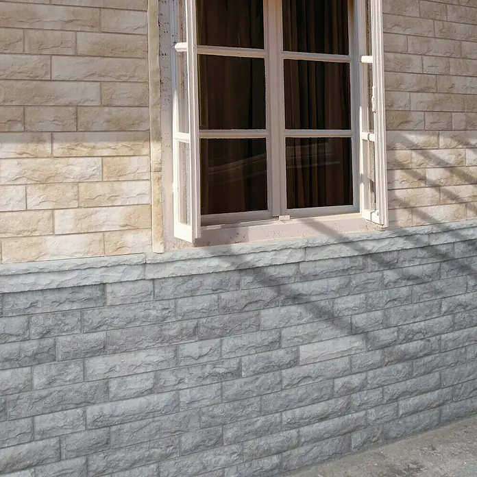 Revestimiento de piedra Cantabria - Gris, Cantidad total: 4 pzs. - Vista de fachada con una ventana blanca, rodeada de ladrillos beige y grises que crean una textura atractiva.