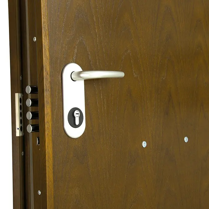 SegureStil Puerta de entrada exterior V500CC Serie V - 90 x 207 cm, Derecha, Nogal, Acorazada - Primer plano de una puerta de madera con manija y cerradura plateadas, que combina seguridad y diseño moderno.