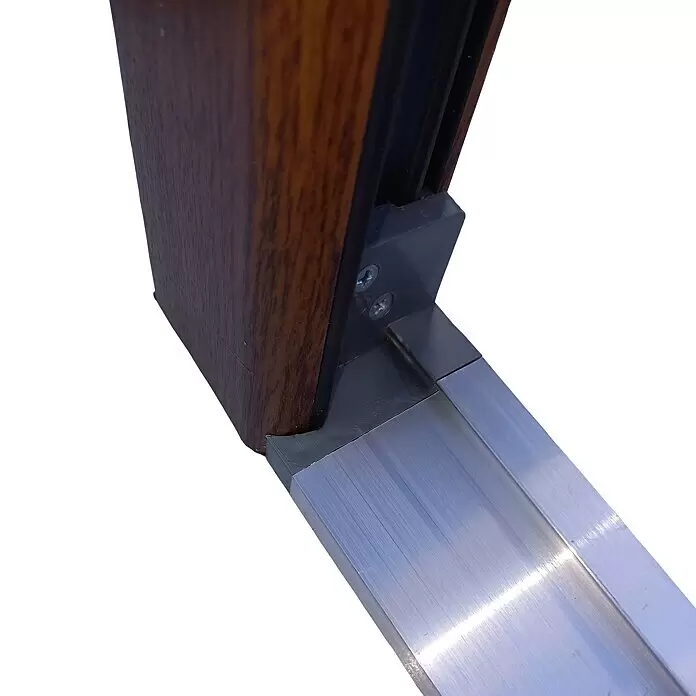 Panto Nebeneingangstür K 504 - 98 x 198 cm, DIN Anschlag: Links, Golden Oak - Nahaufnahme einer braunen Holzoptik-Rahmenecke, verbunden mit einer gebürsteten Aluminiumschwelle durch einen dunkelgrauen Verbinder und Schrauben.