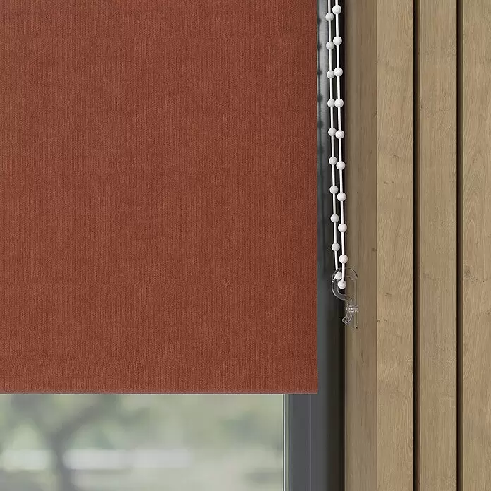 Verdunkelungsrollo Velvet - B x H: 90 x 190 cm, Terra - Rostfarbener strukturierter Rollvorhang, teilweise vor einem Fenster heruntergelassen, mit weißer Perlenzugkette.