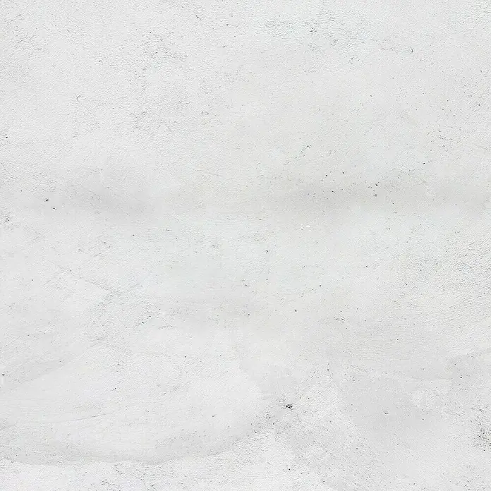 Fleur Kit Microcemento - Greige, 2 kg - Primer plano de una pared blanca que muestra sutiles imperfecciones y una textura delicada que irradia una elegancia sencilla.