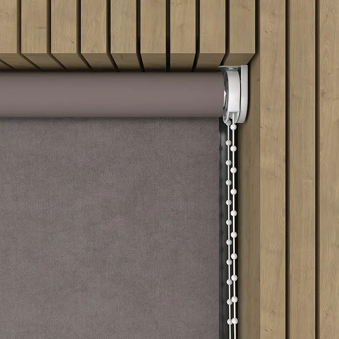 Verdunkelungsrollo Velvet - B x H: 80 x 190 cm, Taupe - Eine Nahaufnahme eines grauen Rollos mit Kettenzug vor einem Holzhintergrund. Das Rollo ist teilweise heruntergelassen und gut sichtbar.