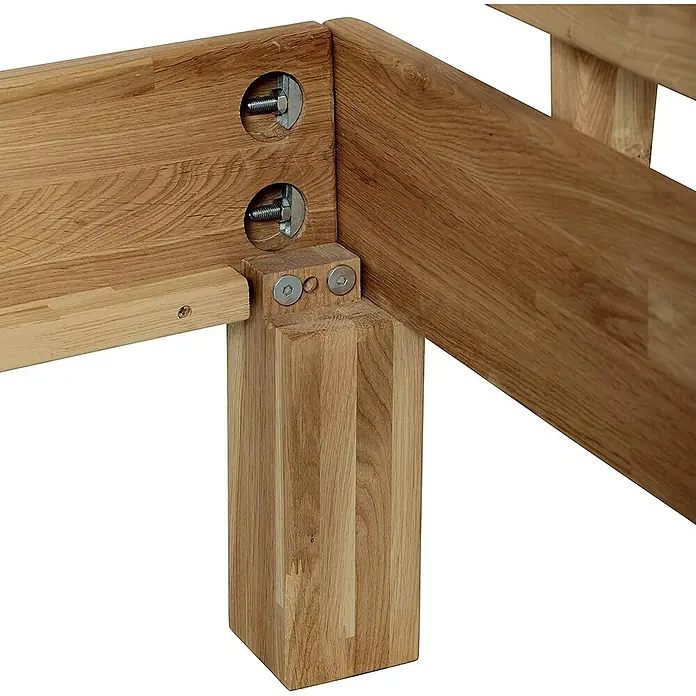 Krok Wood Bett Julia160 x 200 cm, Eiche - Detailansicht eines Holzbetts, das die Eckverbindung mit Bolzen und Muttern zeigt, was die robuste Konstruktion und einfache Montage hervorhebt.