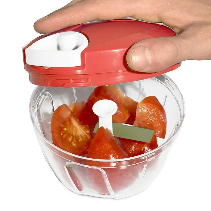 Picadora manual - Ø x Al: 12,3 mm x 9,1 cm, Plástico - Primer plano de un picador manual con tomates rojos en dados, operado por una mano. Práctico para cocina, ensaladas y más.