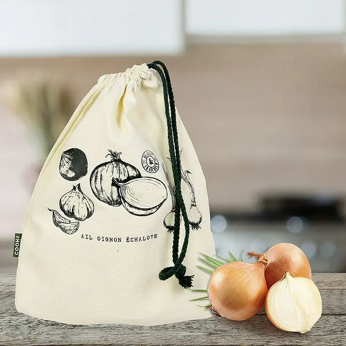 Bolsa de conservación reutilizable - L x An x Al: 1,5 x 21 x 26,5 cm, Tela - Una bolsa de tela con cordón para guardar cebollas con dibujos de cebollas sobre una mesa de madera junto a algunas cebollas.