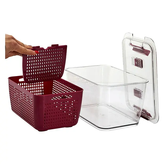 Contenedor hermético - L x An x Al: 18,5 x 28,5 x 15 cm, Número de compartimentos: 2 ud. - Una imagen cercana de una cesta perforada de color burdeos con un tamiz y un recipiente de plástico transparente con tapa, sobre un fondo negro.