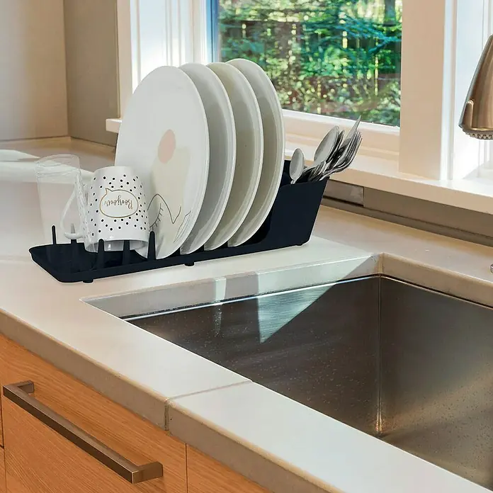 Escurreplatos compacto - L x An x Al: 13 x 44 x 10 cm, Plástico - Un escurreplatos de plástico que muestra platos, tazas y cubiertos sobre una encimera de cocina junto a un fregadero, perfecto para la organización.