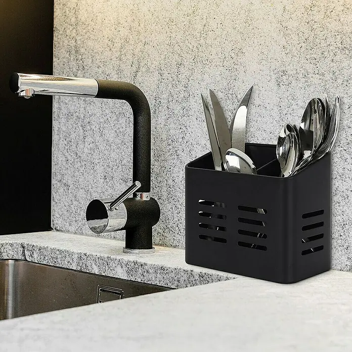 Prensa de cubiertos - 9 x 16 x 13 cm, Plástico, Gris/Negro - Soporte para cubiertos de plástico negro lleno de varios utensilios, situado sobre una encimera junto a un grifo.