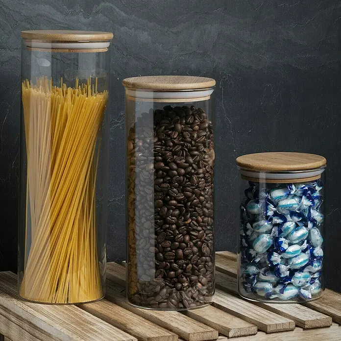 Frasco de vidrio con tapa - Ø x Al: 10,3 x 25 cm, 1,6 l - Tres tarros de cristal con tapas de madera llenos de espaguetis, granos de café y caramelos sobre un palé de madera.