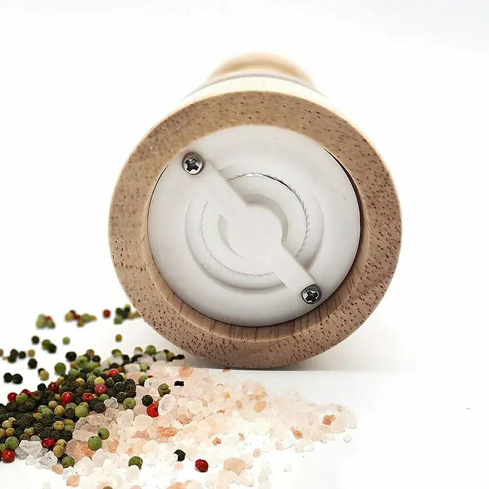 Molinillo de sal y pimienta - Ø x Al: 5 x 16,7 cm, 70 ml - Primer plano de un molinillo de pimienta de madera rodeado de granos de pimienta de colores y sal rosa del Himalaya.
