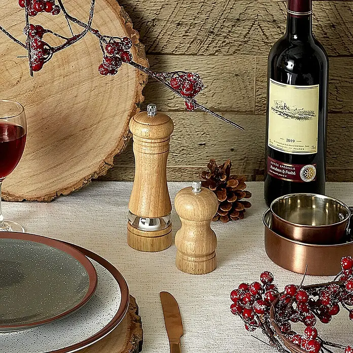 Molinillo de sal y pimienta - Ø x Al: 5 x 16,7 cm, 70 ml - Fotografía de producto con una botella de vino, molinillos de especias, plato y decoración navideña sobre una mesa.