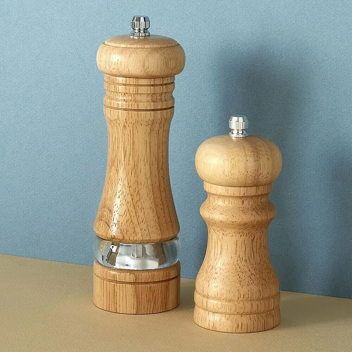 Molinillo de sal y pimienta - Ø x Al: 5 x 16,7 cm, 70 ml - Dos molinillos de pimienta de madera de diferentes tamaños, acentuados con plata, destacan sobre un fondo azul.