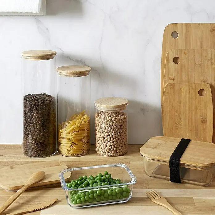 Frasco de vidrio con tapa - Ø x Al: 10,3 x 30 cm, 2 l - Tarros de almacenamiento de alimentos con alimentos y tablas de cortar de bambú en una encimera.