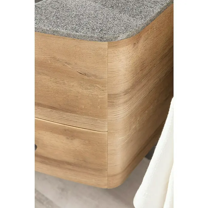 Lanzet Classico Badmöbel-Set CL10LMBC - 99,2 cm, Berg Eiche, Farbe Griff: Chrom, Links - Detailaufnahme eines Waschtischs mit einer grauen Arbeitsplatte und einer hellen, abgerundeten Holzkommode mit Schublade.