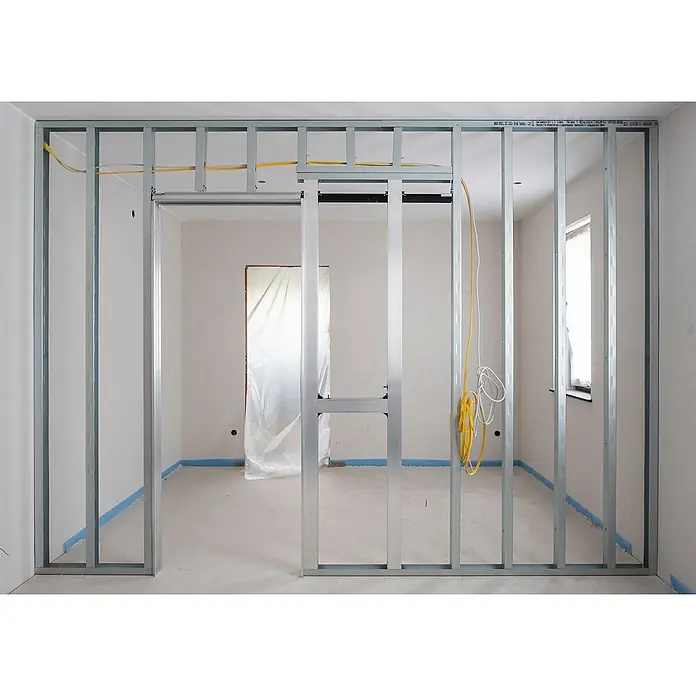Knauf UA-Aussteifungsprofil - 3.500 x 100 x 40 mm - Das Bild zeigt ein unfertiges Zimmer mit Metallrahmenwänden, inklusive einer Schiebetürkonstruktion und sichtbaren gelben Elektrokabeln.