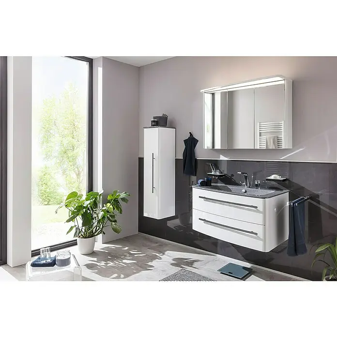 Lanzet Classico Waschtischunterschrank99,2 x 52,4 x 48,2 cm, Weiß, Farbe Griff: Anthrazit, Links - Ein modernes Badezimmer mit einem weißen Waschtisch mit zwei Schubladen, einem Spiegelschrank und einem Hochschrank. Die grauen Fliesen verleihen dem Raum Eleganz.
