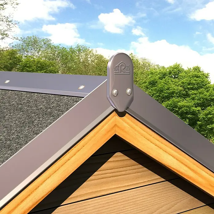 Sarei Piccolo Abschlusskappe - Aluminium, 2 Stk., Natur - Nahaufnahme einer Dachspitze mit einem silbernen Firstbeschlag, der mit Schrauben befestigt ist. Im Hintergrund Bäume und blauer Himmel.