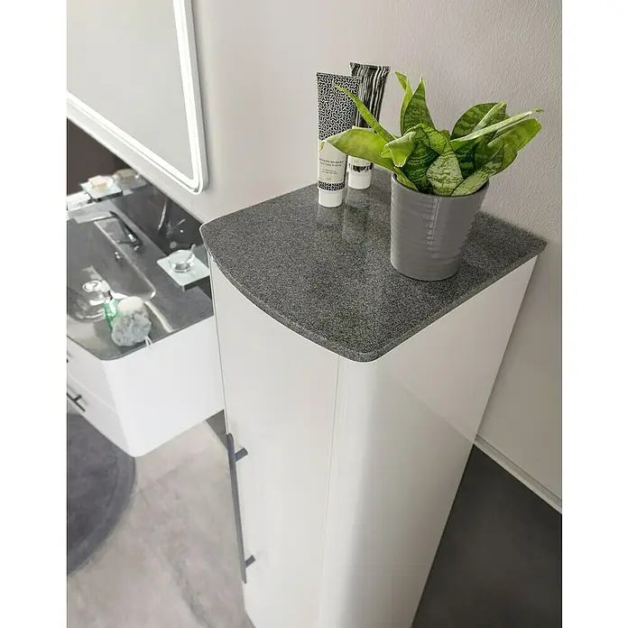 Lanzet Classico Midischrank - B x T x H: 31,2 x 32,5 x 121,4 cm, Weiß, Farbe Griff: Anthrazit, DIN Anschlag: Rechts - Ein Badezimmer-Waschtisch mit grauem Steinaufsatz, auf dem eine Zimmerpflanze und Kosmetikprodukte stehen. Das Möbelstück ist stilvoll und modern.
