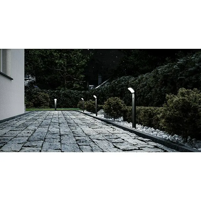 Starlux Außenstehleuchte Udine - 7 W, Farbe Gehäuse: Silbergrau, Warmweiß, 132 x 124 x 600 mm, Mit Leuchtmittel - Eine Reihe moderner Gartenleuchten säumt einen gepflasterten Weg, der durch einen üppigen Garten führt. Die Leuchten werfen ein sanftes Licht.