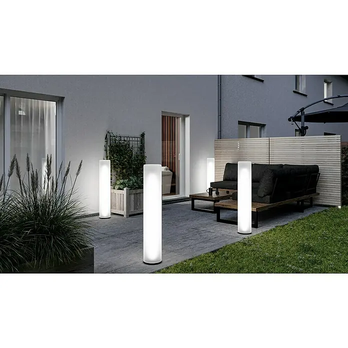 New Garden Außenstehleuchte Fity - Höhe: 100 cm, IP65, Weiß - Gartenansicht mit vier stilvollen LED-Außenleuchten, die eine angenehme Atmosphäre schaffen. Die schlanken Leuchten erhellen Terrasse und Garten.
