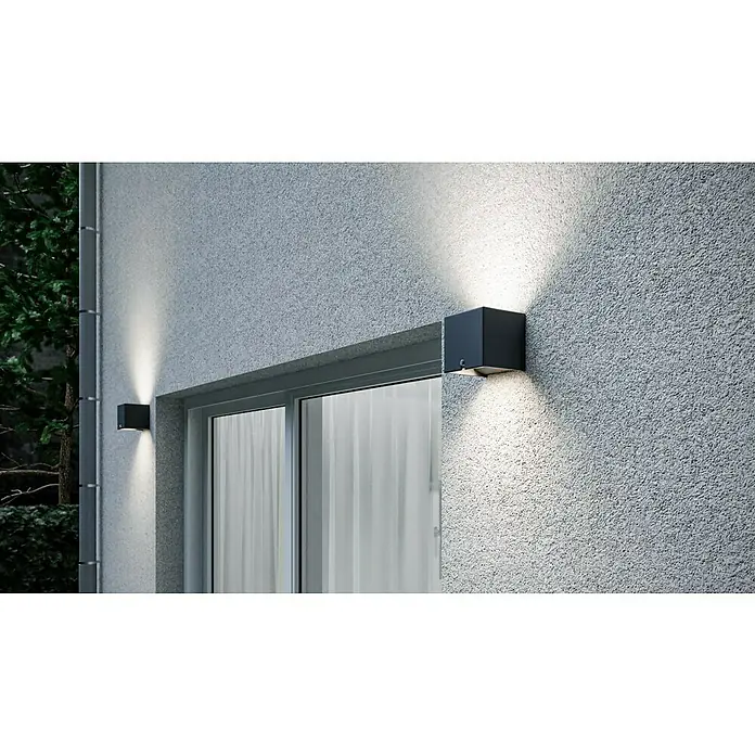 Starlux LED-Sensor-Außenwandleuchte Umea - 10 W, L x B x H: 10 x 10 x 10 cm, Anthrazit, Warmweiß - Zwei schwarze Würfel-Wandleuchten beleuchten eine graue, strukturierte Außenwand neben einer Schiebetür und sorgen für ein modernes Erscheinungsbild.