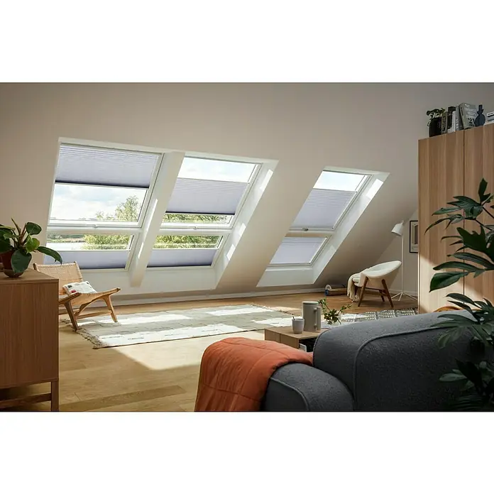Velux Dachfensterplissee FHL UK08 1282SWL - Farbe: Grau - 1282SWL, Farbe Schiene: Weiß, Manuell - Ein Dachzimmer mit Dachfenstern, ausgestattet mit Verdunkelungsrollos, die für Privatsphäre und angenehmes Licht sorgen.