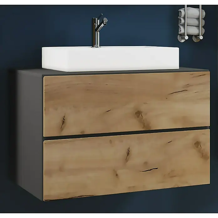 VCM Lendas Badmöbel-Set - 61 cm, Anthrazit/Honig-Eiche - Badezimmermöbel mit Waschtisch und zwei Schubladen in Holzoptik vor dunkelblauem Hintergrund.