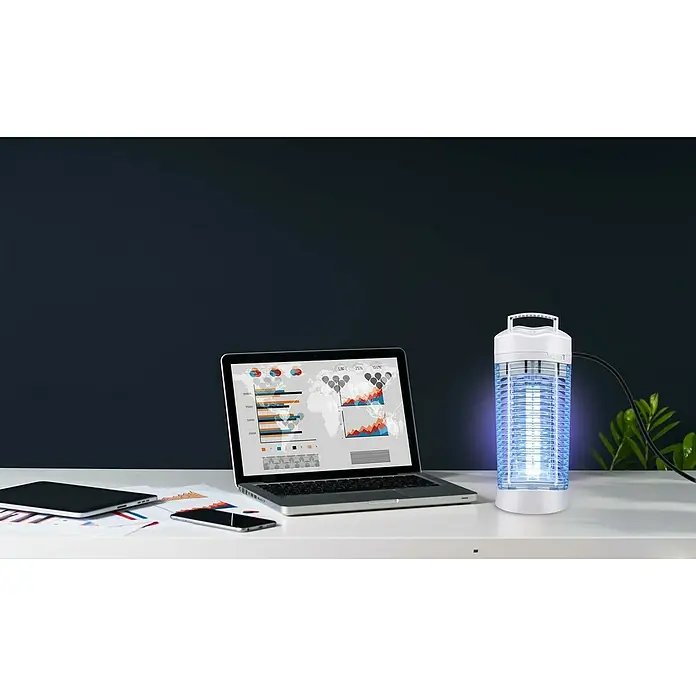Farolillo antimosquitos LED - 12 W, Blanco - Una trampa para insectos se sitúa en un escritorio al lado de un portátil y otros dispositivos. Ideal para el control de insectos en interiores.