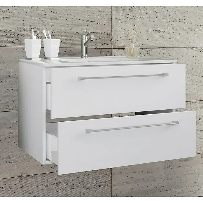 VCM Badinos Badmöbel-Set - 81 cm, Weiß, 2 -tlg. - Ein weißer Badezimmerschrank mit zwei Schubladen, die teilweise geöffnet sind, und silbernen Griffen. Badarmaturen sind sichtbar.
