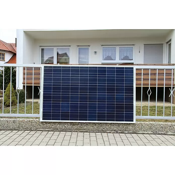 Sunset Balkonkraftwerk Sunpay 300 Plus - 0% MwSt. (gem. § 12 Abs. 3 UStG) - Monofazial, 300 W, L x B x H: 3,5 x 99,2 x 148 cm - Dunkelblaues Solarpanel mit weißen Gitterlinien und weißem Rahmen, montiert an einem weißen Metallzaun vor einem Haus.