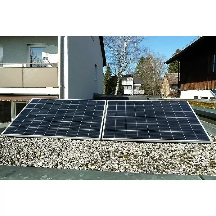 Sunset Balkonkraftwerk SunPay 600W inkl. Halterung - 0% MwSt. (gem. § 12 Abs. 3 UStG) - Monofazial, 600 W, L x B x H: 3,5 x 99,2 x 148 cm - Zwei schwarze Solarpaneele mit silbernen Rahmen sind auf einem kiesbedeckten Flachdach installiert und fangen Sonnenlicht ein.