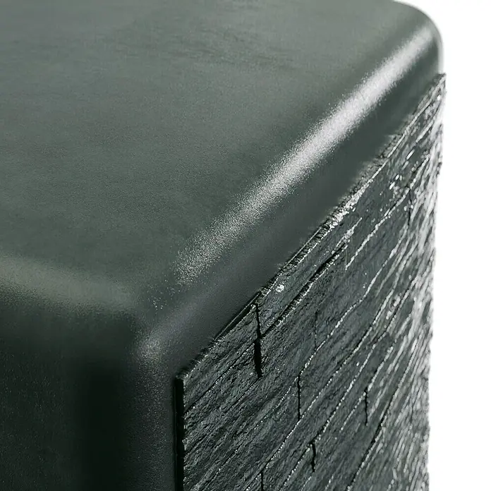 4rain Regenspeicher Slim Stone - 500 l, Grau - Nahaufnahme eines dunklen, quaderförmigen Objekts mit einer glatten Oberseite und einer texturierten, schieferartigen Seite.